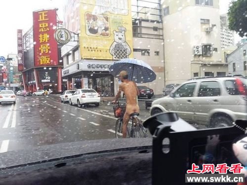 男子全裸骑车撑伞 网友称多此一举 图