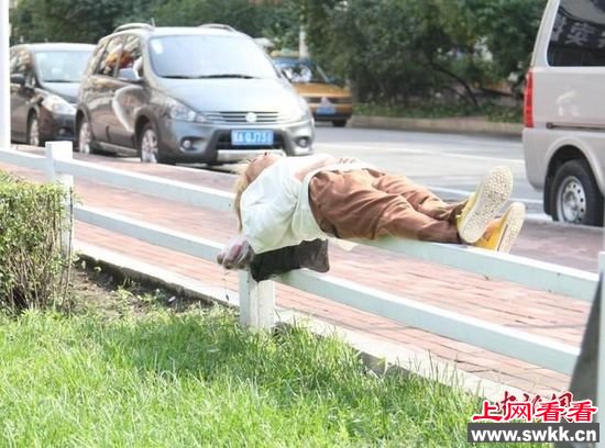 当代小龙女女子躺5cm宽铁栏杆上酣睡 图