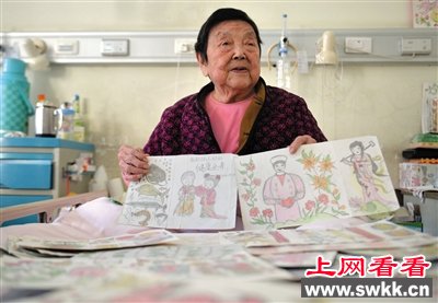昨日，广外医院，王月珍老人坐在病床上展示自己的画作。这些作品都画在废旧药盒的背面。 新京报记者 吴江 摄