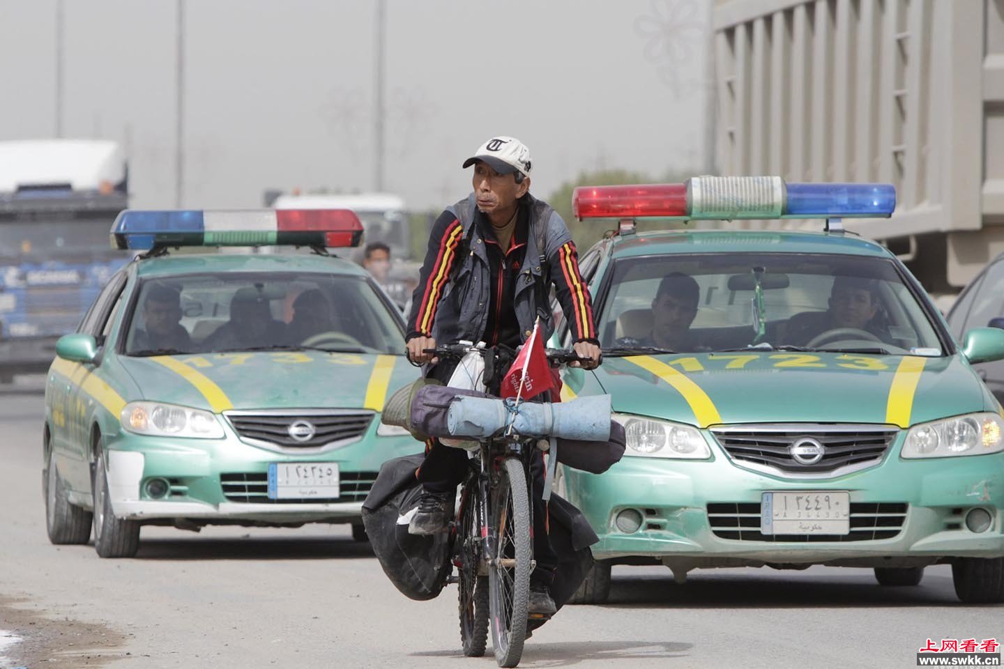 中国男子骑车环游世界到伊拉克军警“护送”