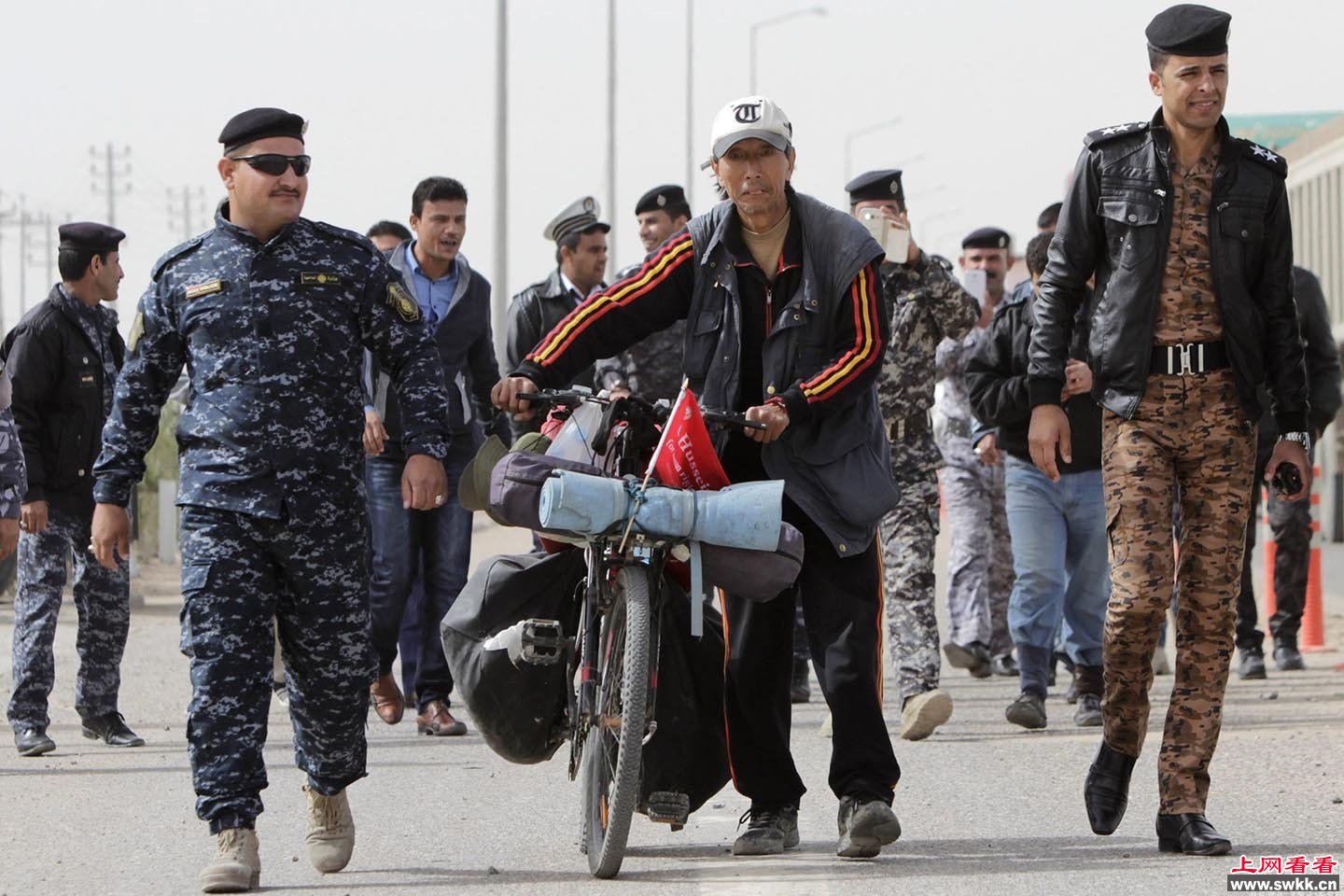 中国男子骑车环游世界到伊拉克军警“护送”