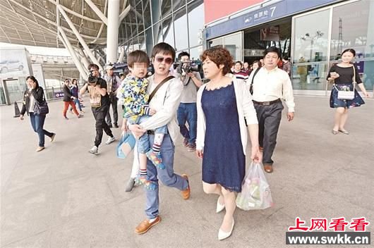 金鑫抱着儿子，和父母走出武汉火车站 楚天都市报记者王永胜摄