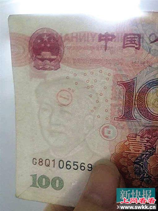 刘先生声称从ATM机中取出了错版币,可以看到水印处有一个印章。