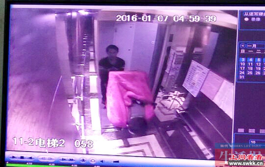 视频监控拍到两名小偷一人用毛毯包着保险柜背下楼，一人在后面协助托着。